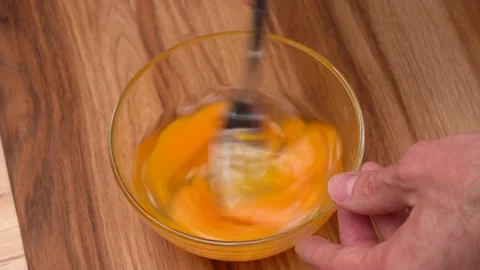 Men's hands interfere with a metal fork raw eggs in a glass bowl 動画素材 237029703