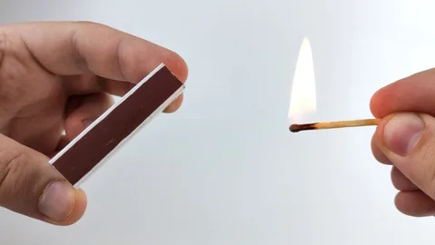 Men's hands light a match on the boxes. Macro video of a match head ignition. Co Stock Footage 126537768