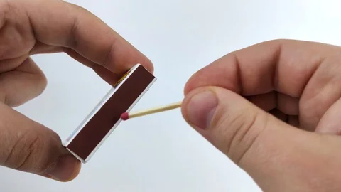 Men's hands light a match on the boxes. Macro video of a match head ignition. Co Stock Footage 126537787