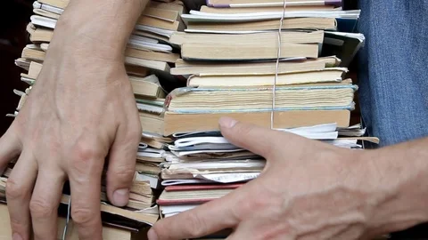 Men's hands move along two bound stacks of books, a close plan Stock Footage 114292741