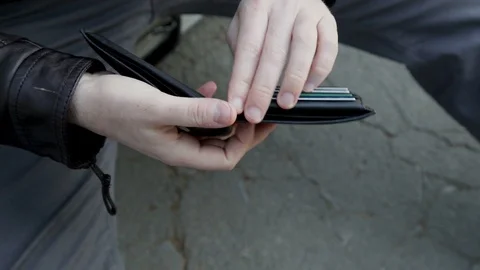 Men's hands  nervously gut an empty wallet, coins fall out Vidéo 102282992