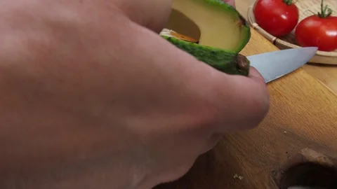 Men's hands open avocado in half Stock Footage 129807281