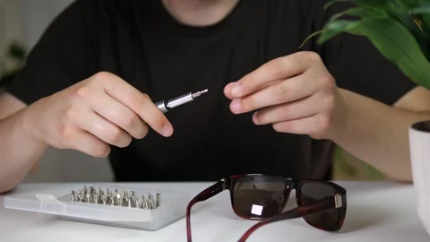 Mens hands prepare a screwdriver at the table to fix their things. Selecting Stock Footage 313866689