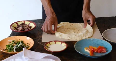 Men's hands preparing and wrapping traditional shawarma wrap or gyro with meat Stock-Footage 151471488