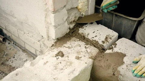 Men's hands put cement mortar on the silicate blocks Stock Footage 112804387