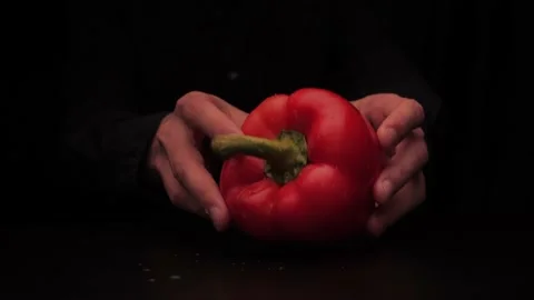 Men's hands put on the table red colored bell pepper on a dark background Stock-Footage 142863609