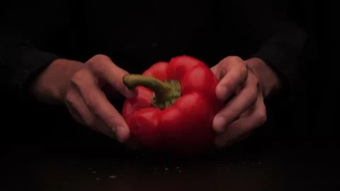 Men's hands put on the table red colored bell pepper on a dark background Stock-Footage 144370414