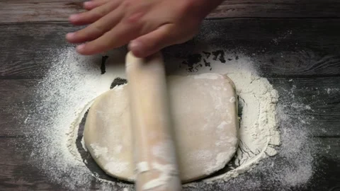 Men's hands roll out pizza dough on a wooden table, top view. Stock Footage 240850488
