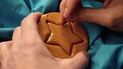 Men's hands scratch brown sugar candy with metal needle pattern in form of star Stock Footage 162136670