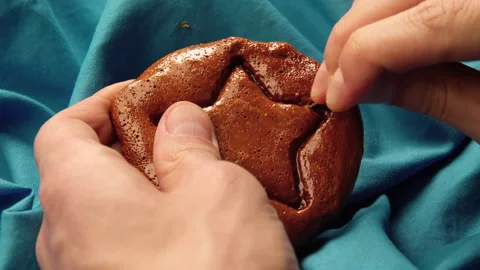 Men's hands scratch brown sugar candy with metal needle pattern in form of star Stock Footage 162137321
