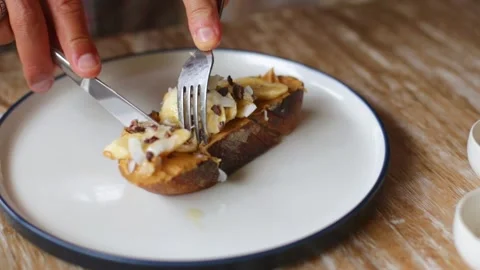 Men's hands slice crispy toast with bananas and nut paste. Stock Footage 266764463