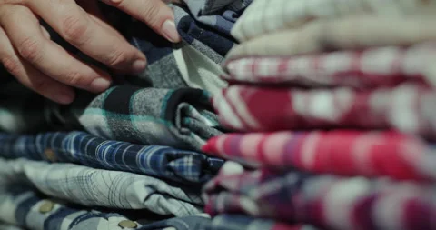 Men's hands sort clothes in a stack on the shelf Stock Footage 143790950