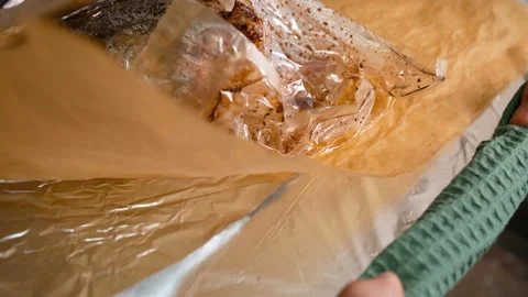Men's hands take out a baking tray with a chicken baked in a bag. Stock Footage 250309145