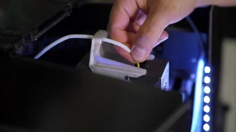 Mens hands thread a plastic thread into the teeth of a printer for 3d printing. Stock Footage 311151812