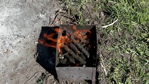 Men's hands throw a small splinter into the burning brazier, top view Stock Footage 101650630