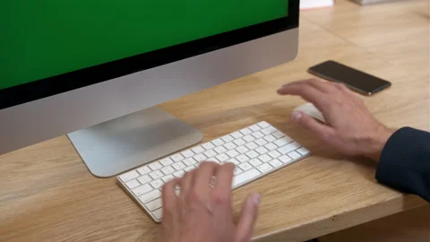 Men's hands type on a white keyboard, then scroll through a page on a monitor Stock Footage 231894260