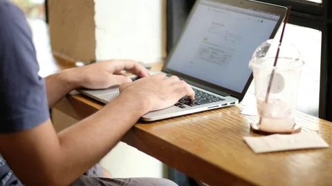 Men's hands typing on computer in the coffee shop Stock Footage 75856294