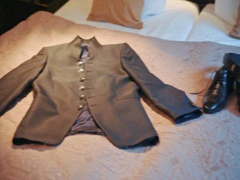 Men's jacket lying on the bed Stock Footage 75559043