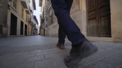 Men's legs go on camera on a cobblestone street, Palma de Mallorca, Spain Stock Footage 83628045