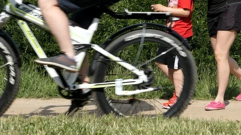Men's Legs Go Down The Path And Men Riding Bike Stock Footage 90971580