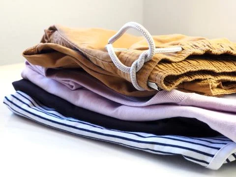 Men's summer clothes. Stack of sleeveless t-shirts and shorts. Stock Photos