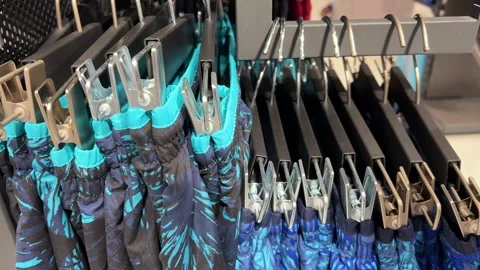 Men's Swimming Trunks with Blue Pattern Hanging on Retail Display, Swimwear Stock Footage 295730520