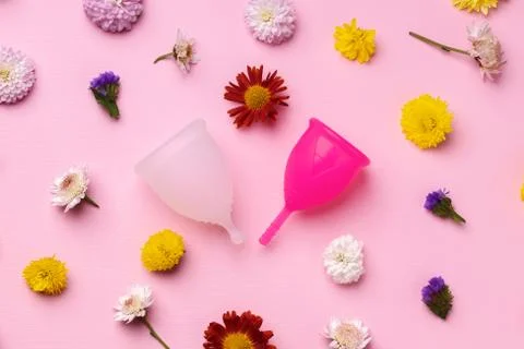 Menstrual cup on floral pattern background top view Stock Photos