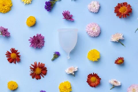 Menstrual cup on floral pattern background top view 스톡 사진