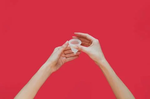 Menstrual cup in hands on pink background. Alternative feminine hygiene produ Stock Photos