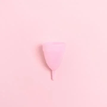 Menstrual cup on pink background Stock Photos