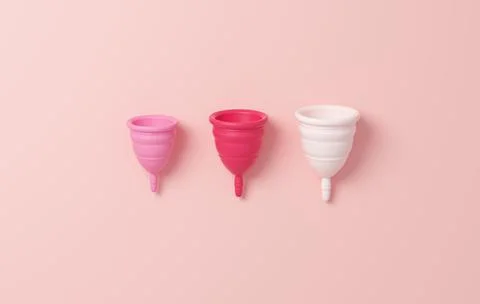 Menstrual cup in three different sizes isolated on a pink background. Zero wa Stock Photos