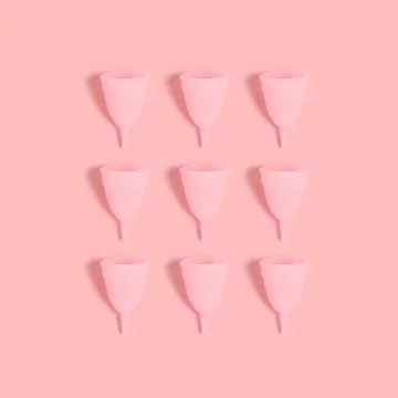 Menstrual cups layout on a pink background. Stock Photos