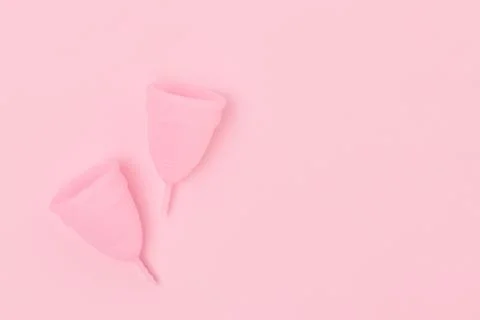 Menstrual cups on a pink background. Stock Photos