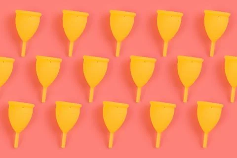 Menstrual yellow cups pattern on a pink background. Monochrome zero waste con Stock Photos