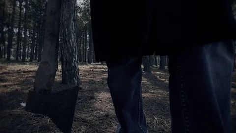 Mentally ill man walking with axe in woods in close up Stock Footage 105294025