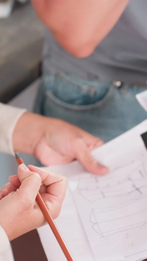 Mentor demonstrates clothing pattern alterations using samples, Fashion Stock Footage 330799158