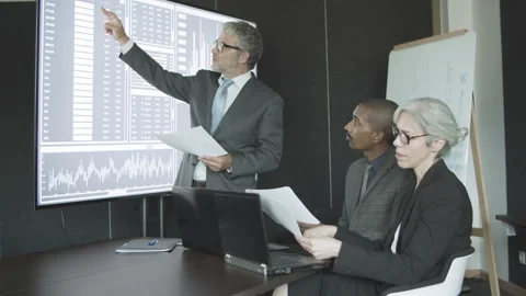 Mentor explaining financial diagrams to interns Stock Footage 146638231