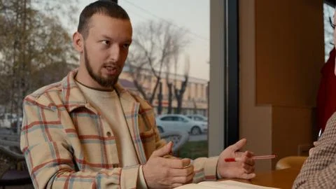 Mentor explaining key lesson points with a hand gesture to the colleague Stock Photos