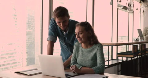 Mentor helps to trainee with corporate software application on laptop Stock Footage 153821573