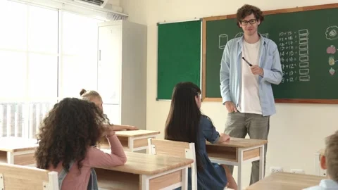 Mentor looking around classroom while standing in front of blackboard. Pedagogy. Stock Footage 276438379