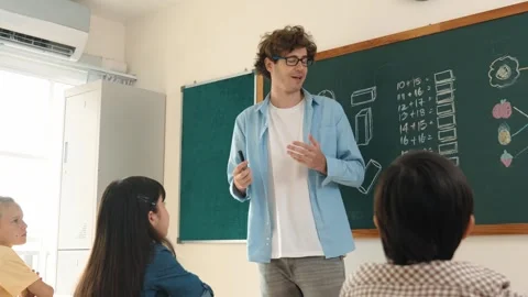 Mentor looking around classroom while standing in front of blackboard. Pedagogy. Stock Footage 279894046