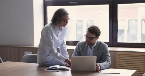 Mentor teach apprentice, explain program, share knowledge at workday 스톡 동영상 237343568