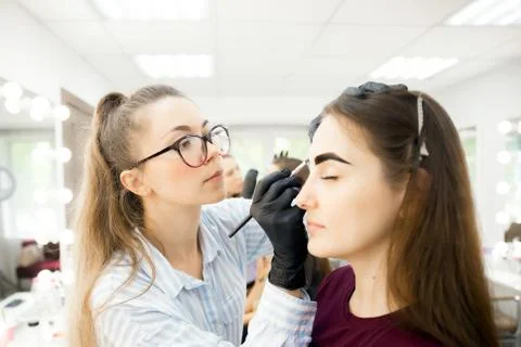 Mentor teaches master workshop correction and tint coloring of eyebrows Stock Photos