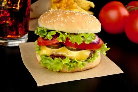 Menu- big cheeseburger with french fries and glass of cola on wooden black de Stock Photos