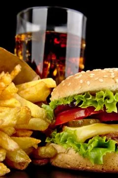 Menu- big cheeseburger with french fries and glass of cola on black Stock Photos