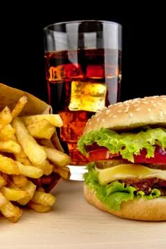 Menu- big cheeseburger with french fries and glass of cola on wooden desk on Stock Photos