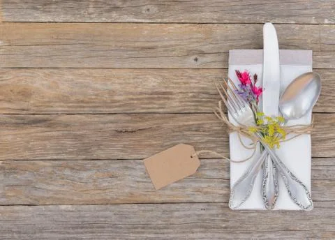 Menu, dinner table setting with silverware, napkin, blossoms and empty tag Stock Photos