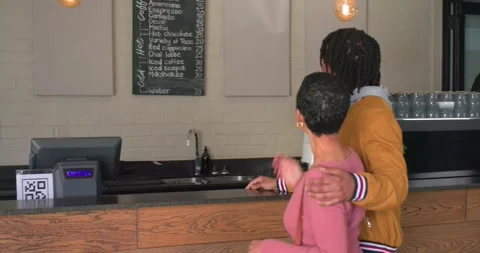 Menu urging diverse couple walking to counter, man pointing board, barista Stock Footage 344644742