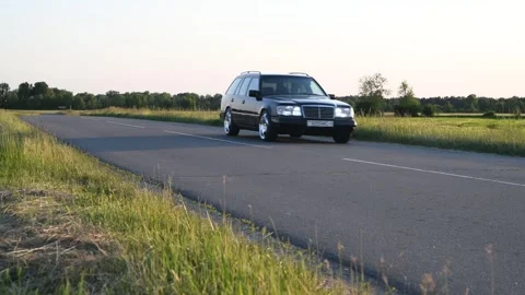 Mercedes-Benz E-Class E220 S124 moves along the road. Video stock 295770845
