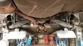 Mercedes CLK low angle in service garage on lifting plattform for changing tyres 4k or 4k+ Resolution